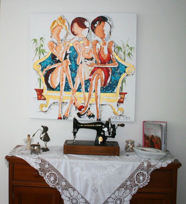 Oh My Goodness hanging above an antique sideboard set with a lace cloth and a vintage Singer sewing machine